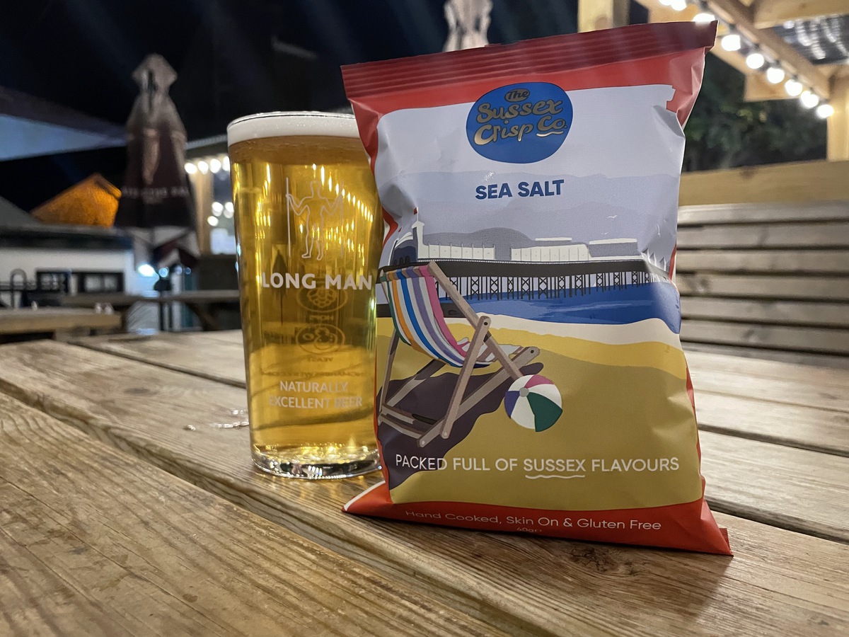 A pint of beer and a packet of The Sussex Crisp Company crisps